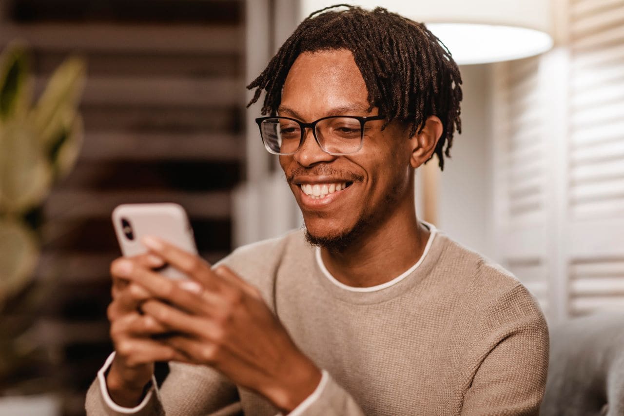 homem feliz com celular na mão solicitando empréstimo na SuperSim